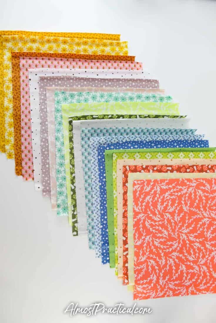 a selection of 10 inch fabric squares in fall colors and prints