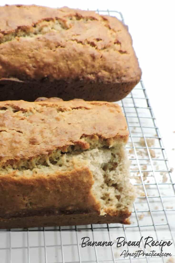 2 loaves of banana bread on a cooling rack with a slice taken and crumbs underneath