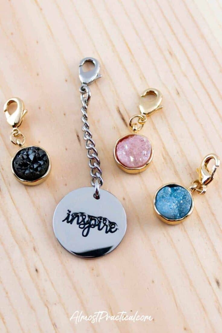 Erin Condren planner charms in druzy black, druzy blush, druzy blue, and the silver Inspire charm.