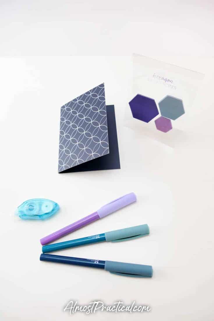 hexagon shaped sticky notes, a small tape dispenser and 3 pens.