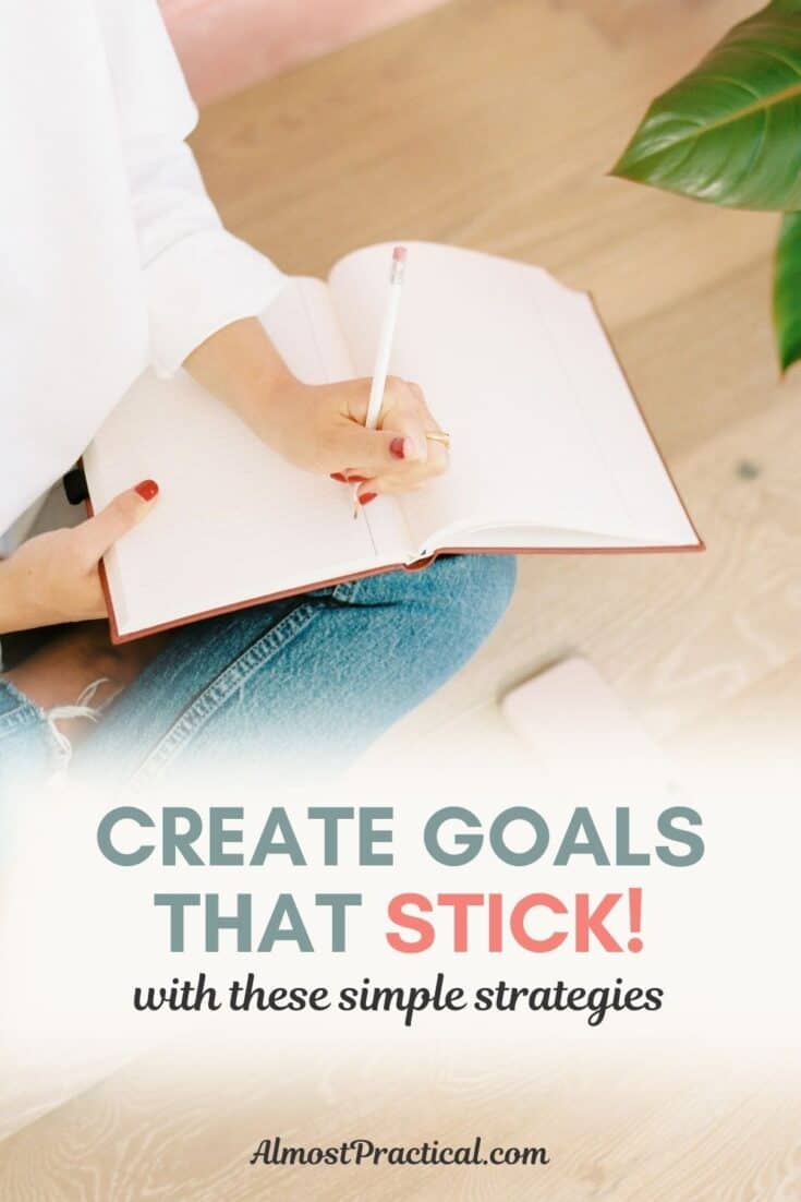 woman wearing jeans writing in notebook while sitting cross legged on a wood floor