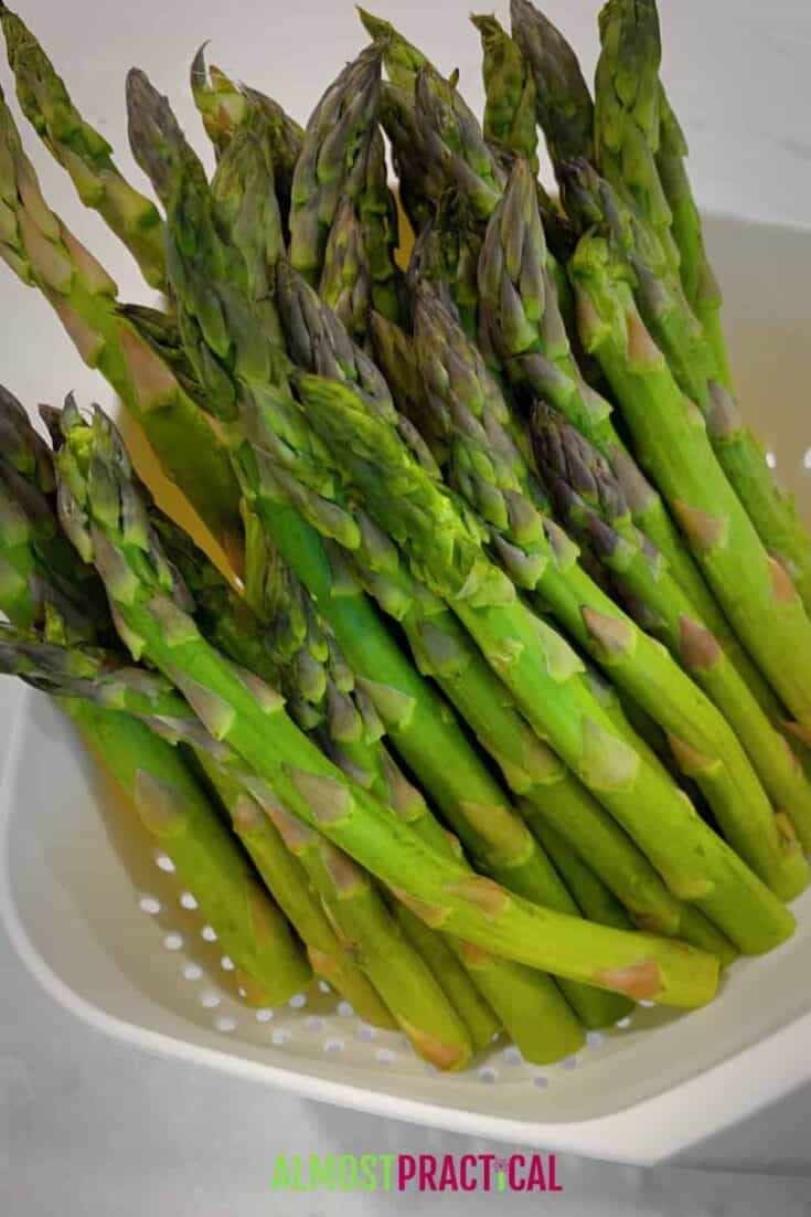 raw asparagus in a strainer