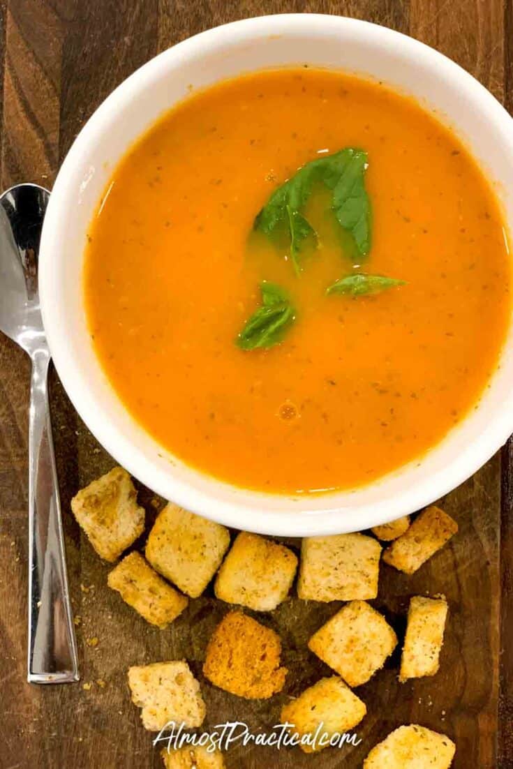 bowl of tomato soup with croutons on the side