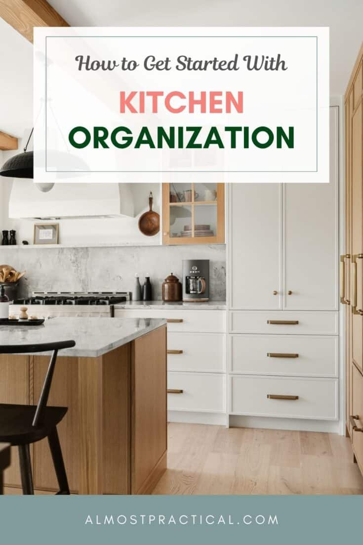 photo of a modern, organized kitchen with white cabinets and center island with a marble countertop.