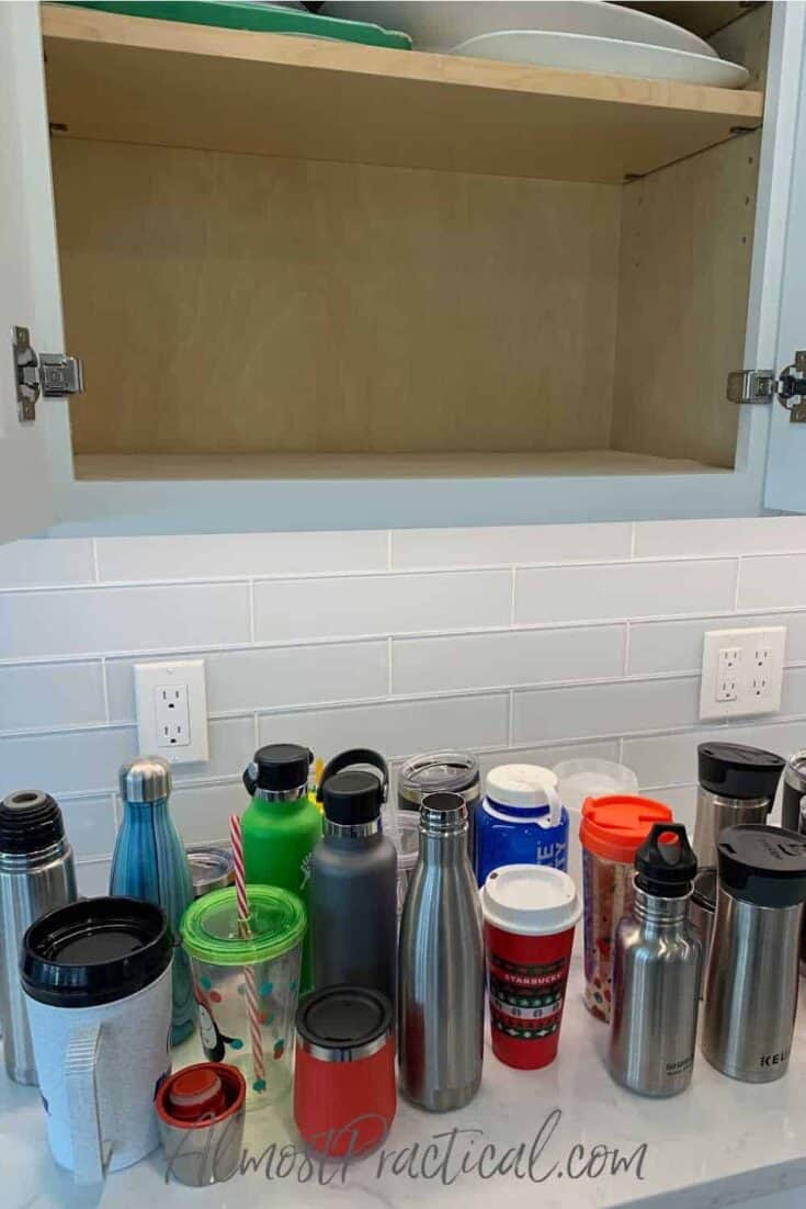 reusable water bottles on counter with empty cabinet above
