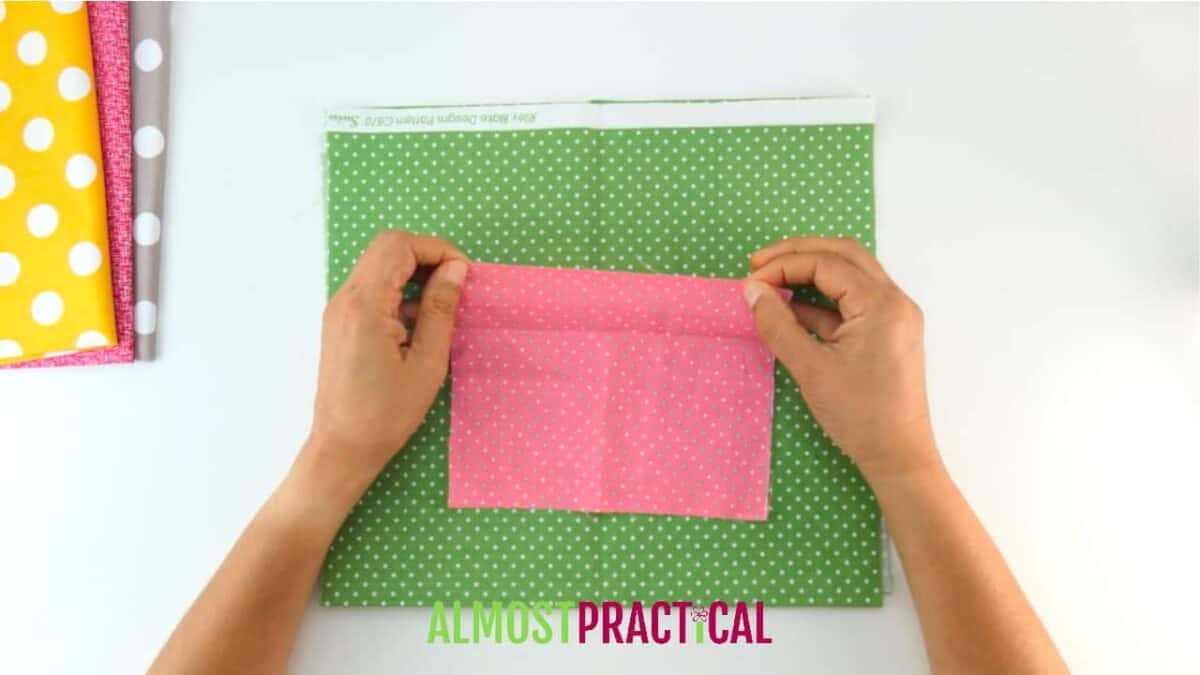 small scrap of pink fabric on top of green fabric