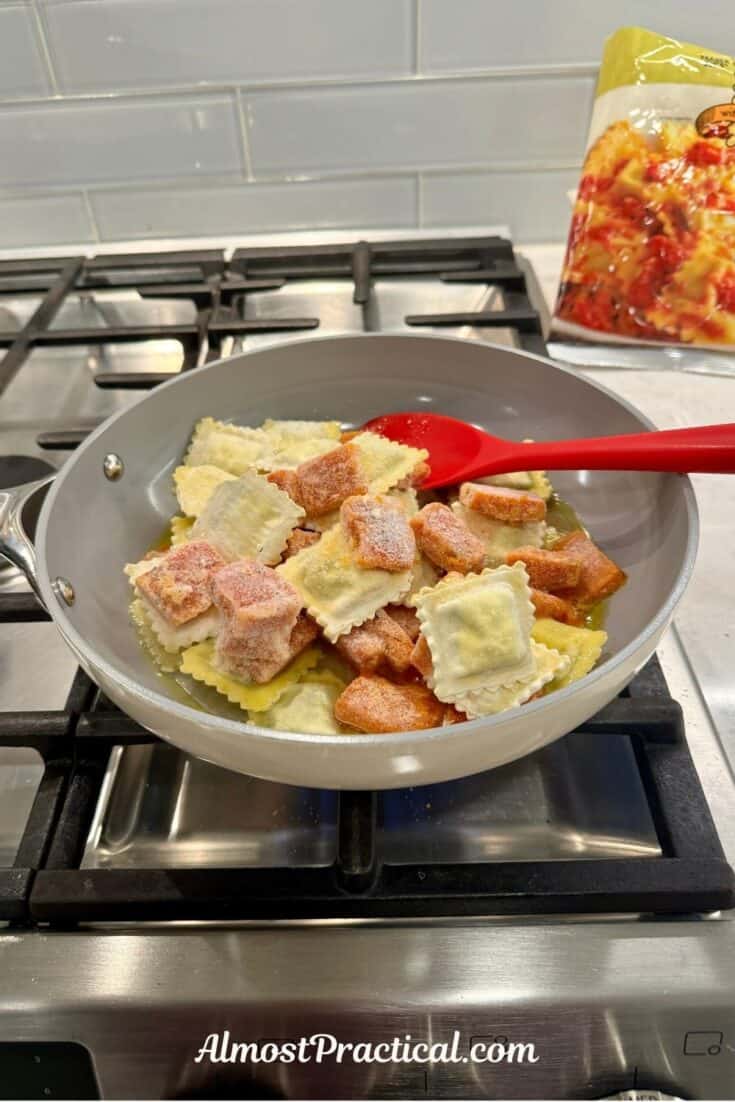 frozen ravioli and sauce cubes in a skillet