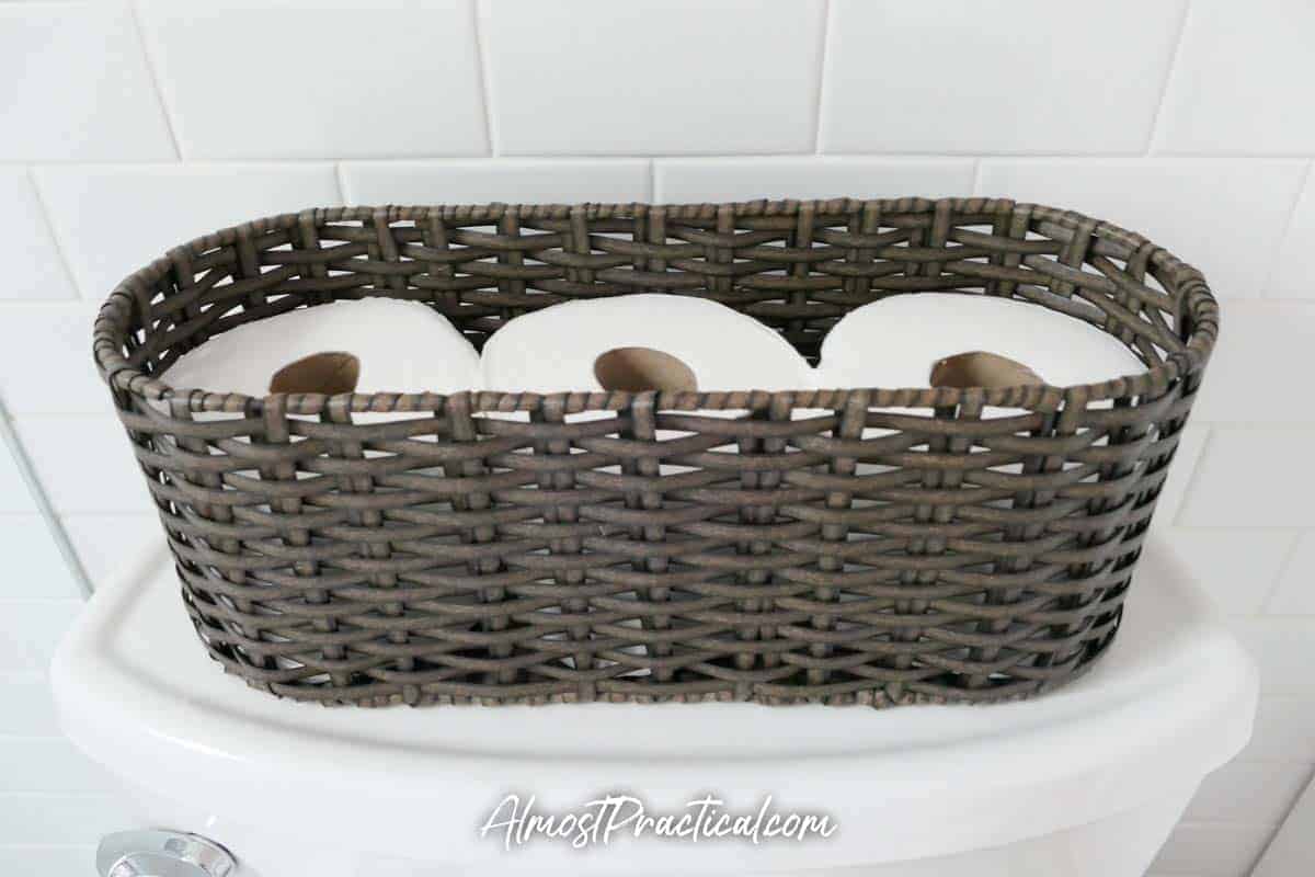 wicker toilet tank topper basket filled with 3 rolls of toilet paper