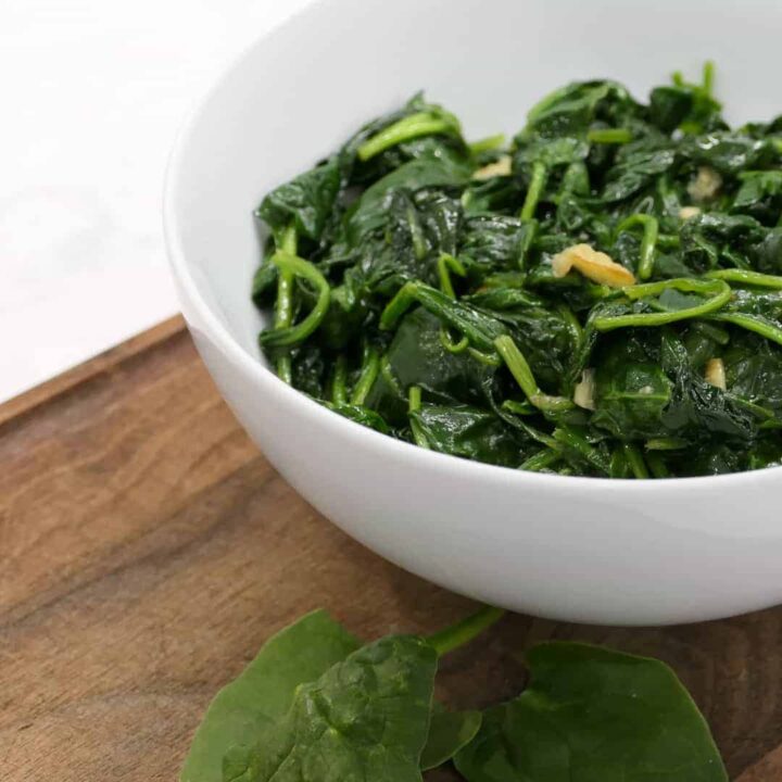 bowl of wilted spinach with garlic side dish