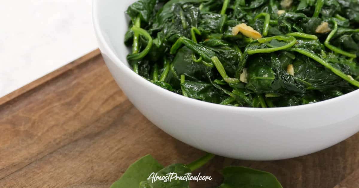 Wilted spinach and garlic in a serving bowl.